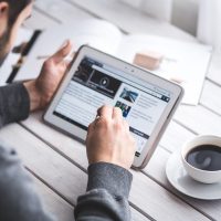 Man, reading, touchscreen — The 8825 Form Is Essential for Multi-Property Owners in Partnerships